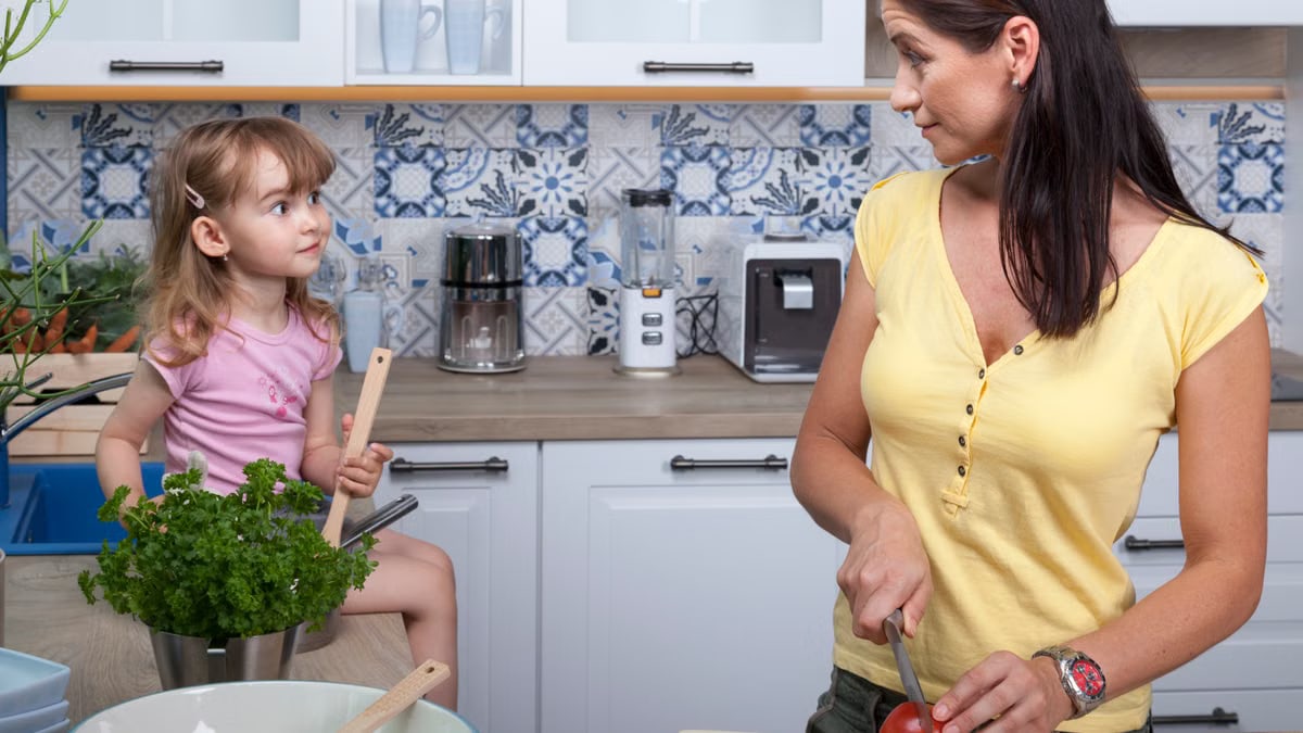 A mother and daughter enjoy cooking together in a cozy modern kitchen, fostering family bonds.